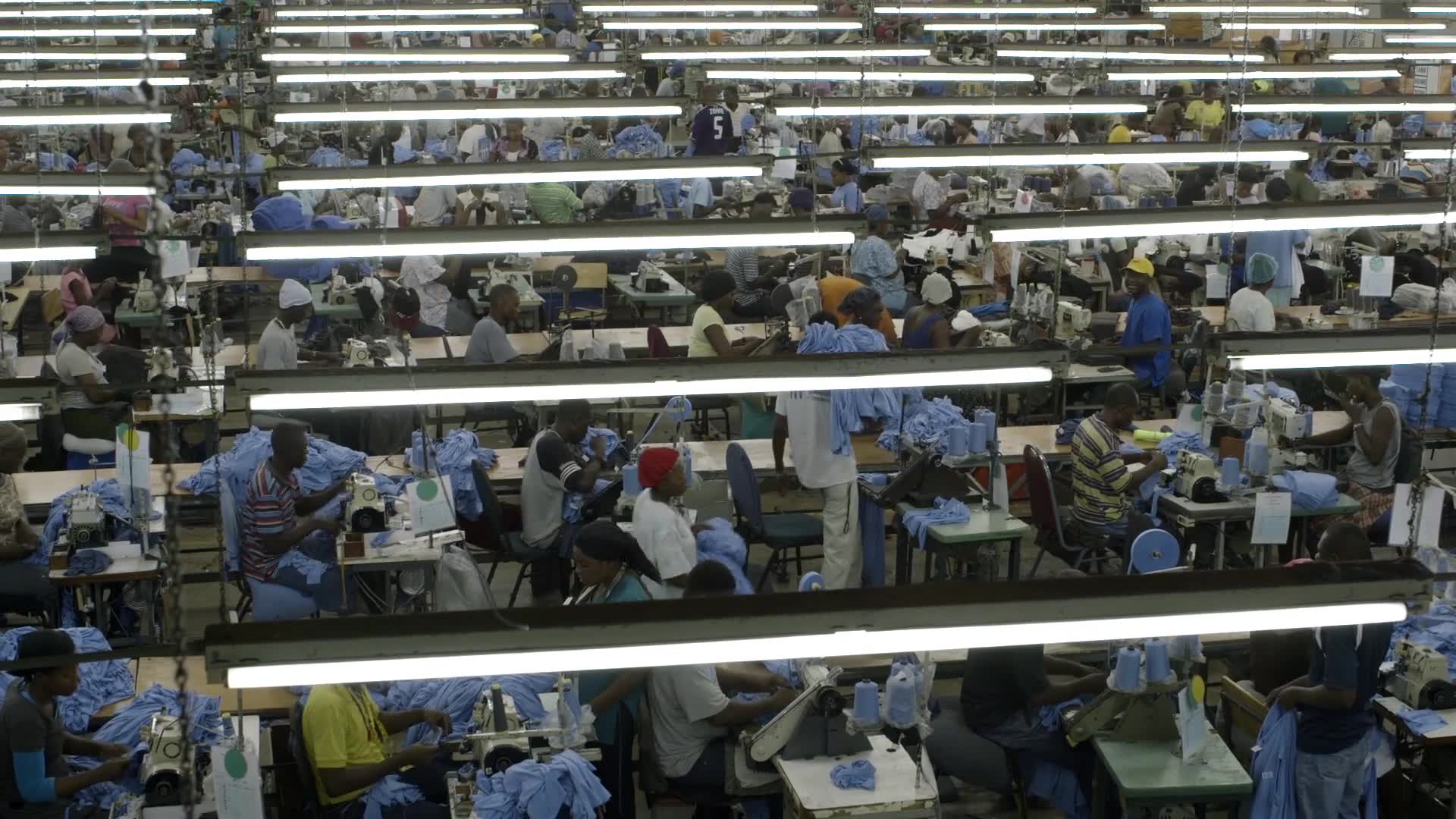 Workers at sewing machines in a large garment factory